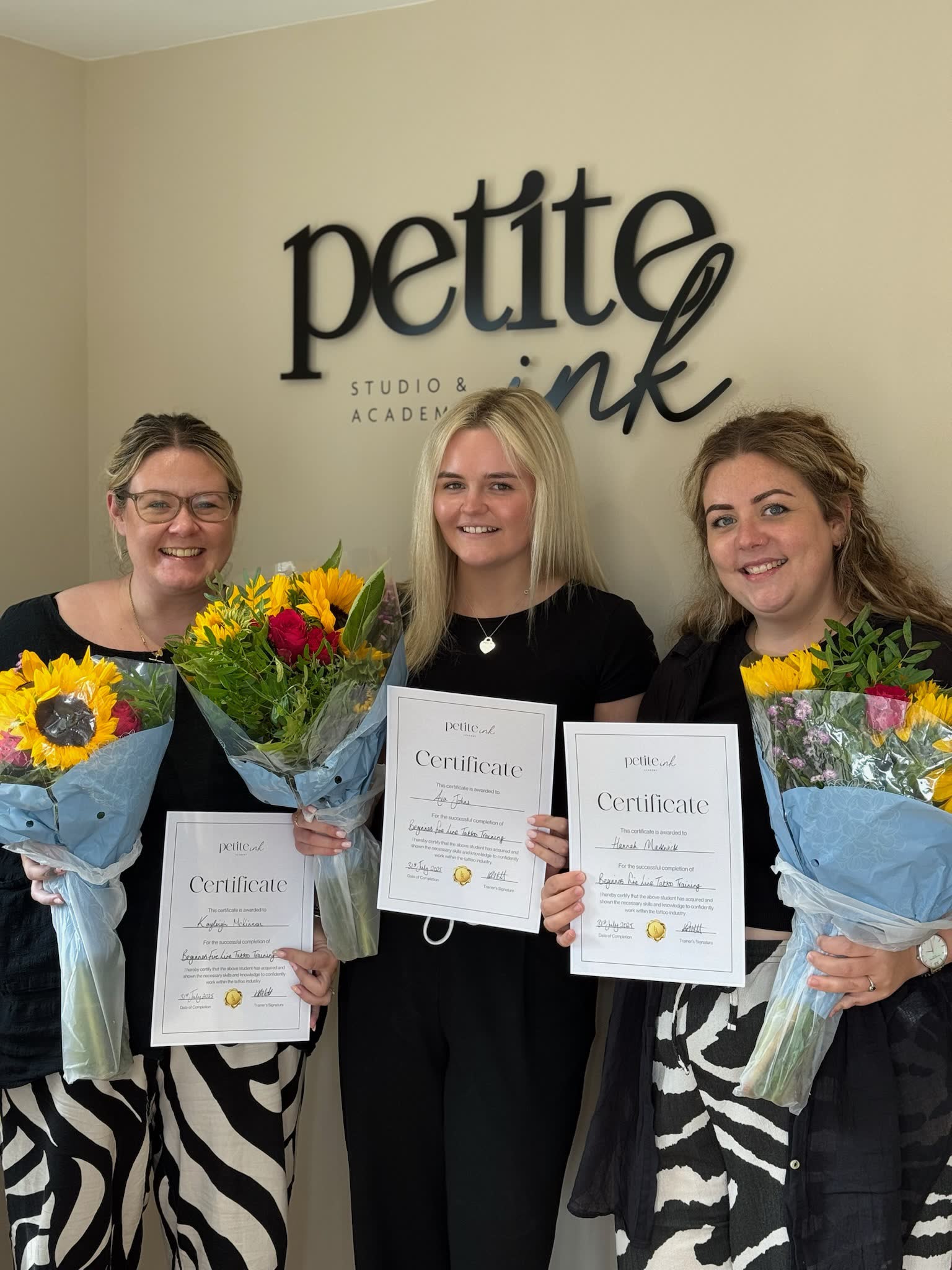 Graduates with sunflowers and certificates