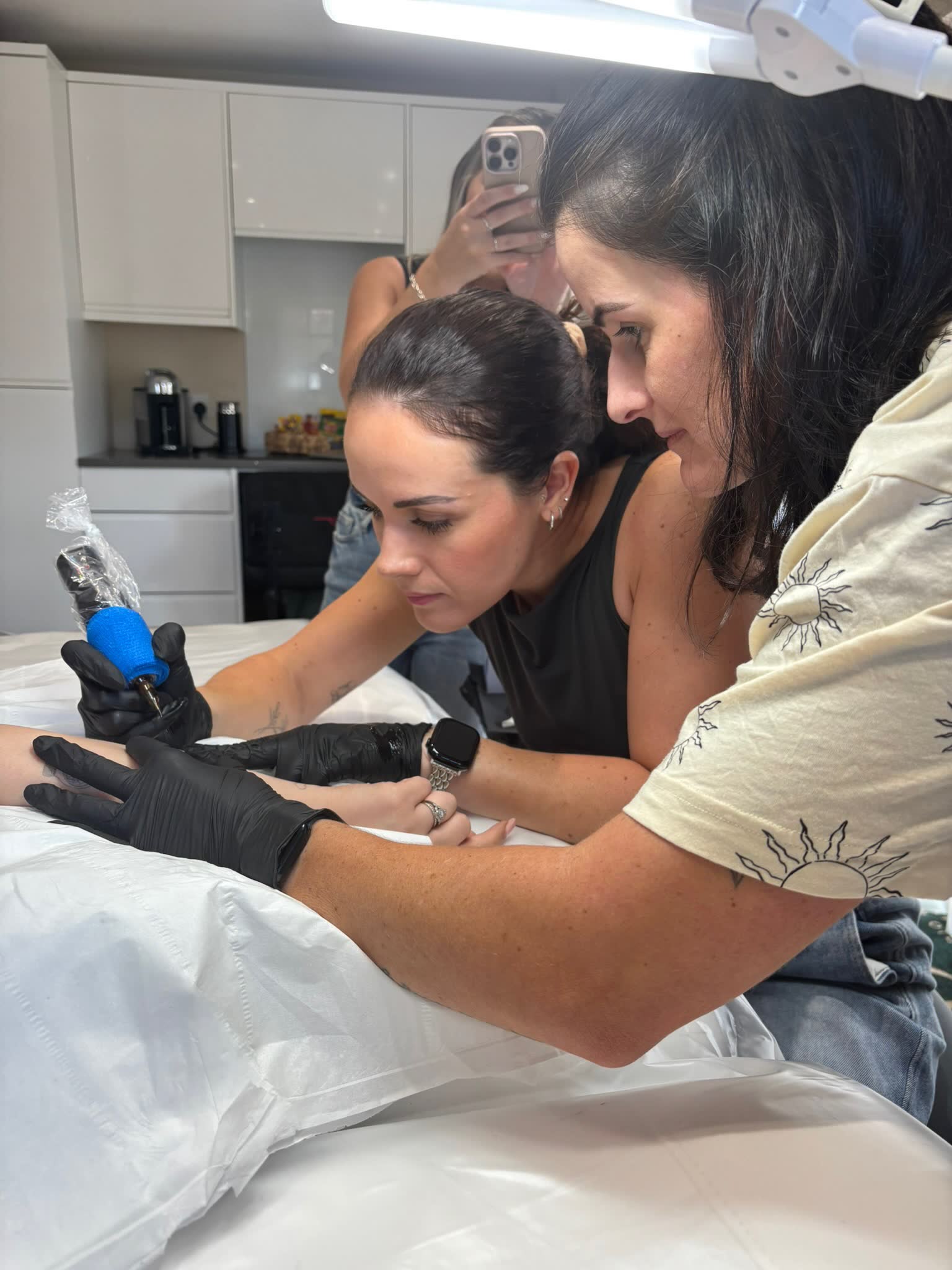 Kayleigh guiding a student through her first model tattoo